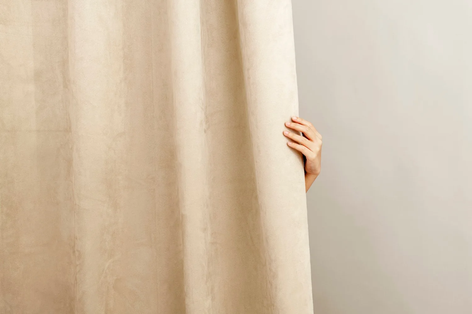 Décor à la maison de rideau beige, avec la main d'une femme